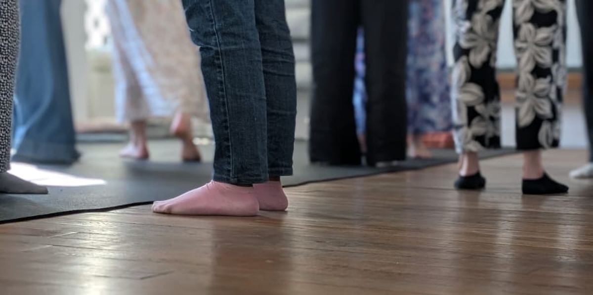 Participants debout sur un parquet, dans une salle lumineuse, pendant une journée de constellations
